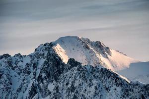 sommet de la montagne enneigée avec le lever du soleil qui brille photo