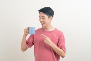 jeune homme asiatique tenant une tasse de café photo
