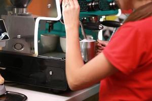 fille barista prépare du café sur la machine à café photo