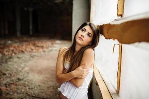 portrait en gros plan d'une jeune fille brune mignonne posée sur un lieu abandonné. photo