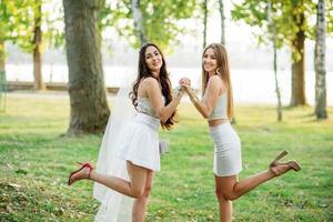 deux amis filles s'amusant sur le parc à la fête de poule. photo