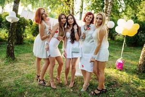 filles portant des robes blanches s'amusant à la fête de poule. photo
