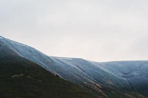 sommet de la montagne enneigée avec des arbres dans les montagnes des carpates en ukraine, en europe. photo