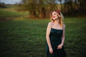 yong élégance fille blonde en robe verte sur le jardin au printemps. photo