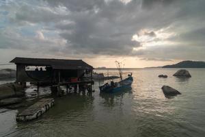 un parc de bateaux de pêche à côté de la maison en bois en mer côtière photo