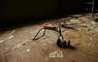 jouets soviétiques de bébé vélo rouillé dans la zone de catastrophe nucléaire de tchernobyl. photo