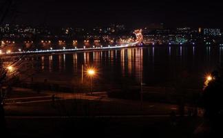 panorama des lumières nocturnes de la ville et des reflets sur le lac à ternopil, ukraine, europe. photo