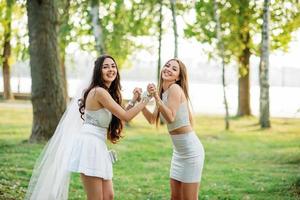 deux amis filles s'amusant sur le parc à la fête de poule. photo