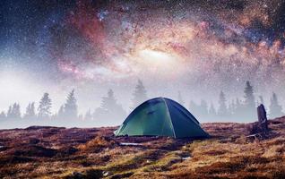 le ciel étoilé au-dessus de la tente dans les montagnes. événement magique en f photo