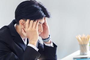 un homme malsain touche le front souffre de fortes migraines, homme d'affaires massant les tempes en gros plan, souffrant d'un fort mal de tête photo