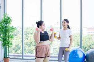 deux femmes asiatiques faisant de l'exercice avec des haltères à la maison photo