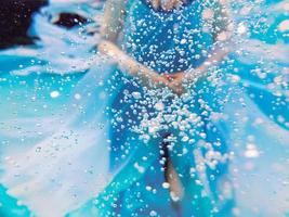 Portrait abstrait de mode sous-marine d'une belle jeune femme en robe bleue a pensé à des bulles d'air photo