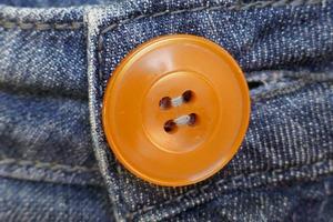 bouton orange sur un jean bleu photo