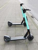 deux trottinettes électriques ou e-scooter garé sur le trottoir photo