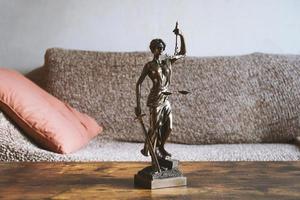 statue de dame justice ou justitia sur table - droit des propriétaires et des locataires photo