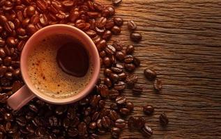 tasse de café avec des grains de café sur fond en bois grunge. photo