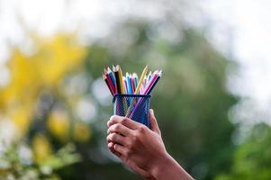mains et crayons de plusieurs couleurs