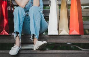 femme shopper s'asseoir avec des sacs de shopping. photo