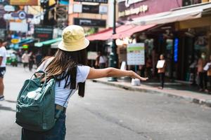 jeune femme asiatique drapeau vers le bas d'un taxi. photo