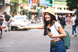 jeune femme asiatique drapeau vers le bas d'un taxi à khaosan photo