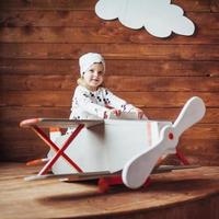 enfant qui joue avec un avion en bois photo