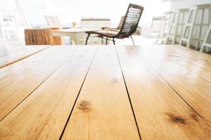 surface de table en bois clair vide avec arrière-plan flou de salon de luxe le jour ensoleillé. photo