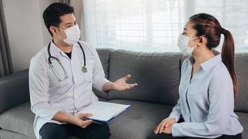 le médecin a rendu visite au patient tout en portant un masque à la maison pour vérifier le traitement du patient pendant l'épidémie de virus. photo