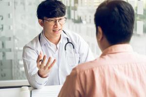 un médecin asiatique examine les éléments anormaux du corps et diagnostique la maladie dans le papier avec le rapport médical du patient. photo