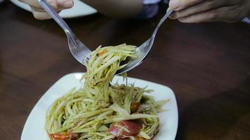 Salade de papaye. cuisine maison dans la cuisine la nourriture la plus populaire en thaïlande est épicée, aigre, délicieuse. les ingrédients clés sont la papaye crue, le citron, la tomate, l'ail, le piment photo