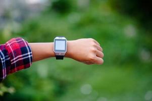 les mains et les montres numériques des garçons regardent l'heure au poignet. l'orientation est ponctuelle. photo