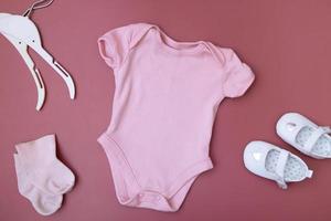 maquette de vêtements pour bébé pour votre texte sur fond rose avec accessoires photo