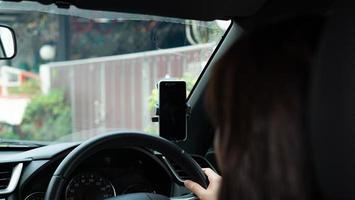 la femme a mis son smartphone dans le support de téléphone de voiture pour le voyage et a utilisé la carte gps. photo