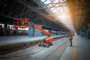 ingénieur chemin de fer en cours de vérification du processus de construction essai de train et vérification des travaux ferroviaires sur la gare avec communication radio .ingénieur portant un uniforme de sécurité et un casque de sécurité au travail. photo