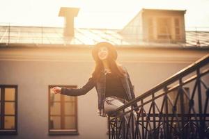 portrait d'une fille heureuse assise sur la balustrade photo