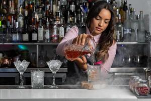 barman servant un cocktail dans un verre photo