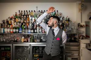 barman faisant un tour avec une bouteille photo