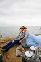 séance photo de mariage d'un couple au bord de la mer. robe de mariée bleue sur la mariée.