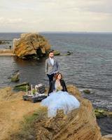 séance photo de mariage d'un couple au bord de la mer. robe de mariée bleue sur la mariée.