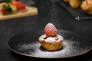 Garniture de gâteau aux fraises maison avec du sucre glace. aliments sucrés. dessert sucré. parfait dessert de saison estivale servi sur assiette. photo