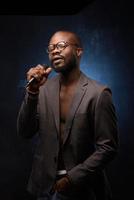 un afro-américain noir chante émotionnellement dans un microphone. portrait de studio en gros plan. photo