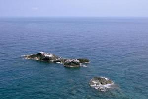 point de roche sur la mer d'un bleu profond en thaïlande photo