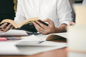 étudiant adolescent travaille sur ses devoirs dans sa chambre et écrit dans un cahier. photo