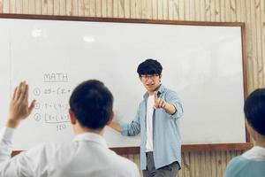 professeur de sexe masculin asiatique enseignant aux élèves en classe photo