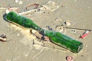 pollutions et bouteille en verre sur la plage des gens photo