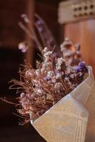 mise au point douce de fleurs séchées dans du papier journal pour la décoration. photo