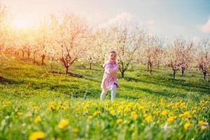 enfant qui court à l'extérieur des arbres en fleurs. photo