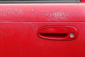 vieille voiture de poignée de porte rouge. variations induites par les conditions météorologiques sur la porte de la voiture. photo