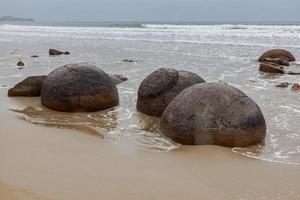 rochers de moeraki à la plage de koekohe sur la côte d'otago coupée par les vagues photo