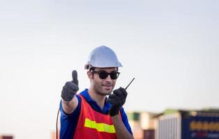 joyeux ouvrier d'usine homme souriant avec les pouces vers le haut en signe de succès photo