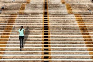 jeune femme qui court dans les escaliers urbains sur fond de béton. photo